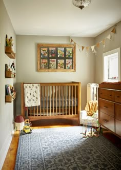 a baby's room with a crib, dresser and bed in it that has a blue rug on the floor