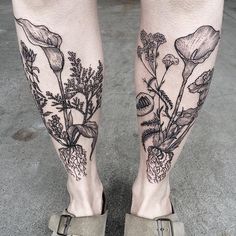 a person's legs with tattoos on them and flowers in the bottom right leg