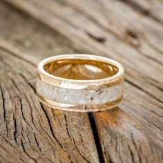 a close up of a wedding ring on a wooden surface