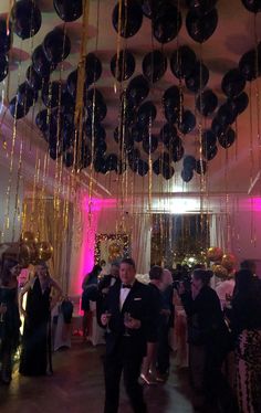 a group of people standing in a room filled with balloons