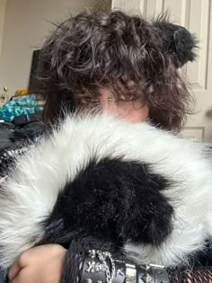 a woman with curly hair wearing a black and white fur coat over her shoulder,