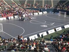 an overhead view of a tennis court with people standing on the sidelines and in the stands