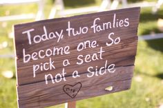 a wooden sign that says today two families become one so pick a seat not a side