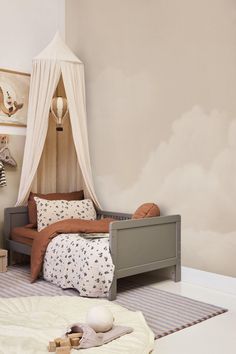 a child's bedroom with a canopy bed and toy animals on the floor next to it