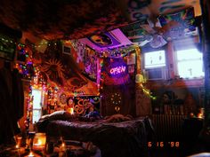 a bedroom decorated for halloween with lights and decorations on the ceiling, bed in foreground