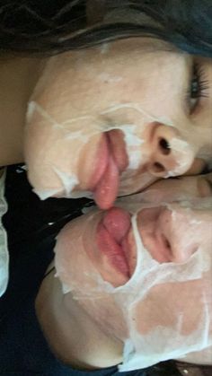 two women with facial masks on their faces and one has her tongue out to the side