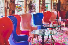 colorful chairs and tables in a room with stained glass windows