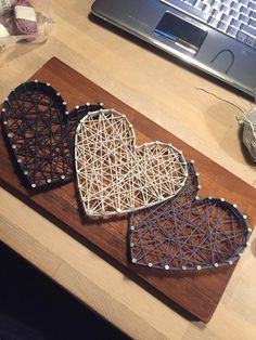 two heart shaped coasters sitting on top of a wooden table next to a laptop