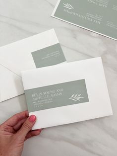 two envelopes are being held by someone's hand