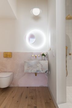 a bathroom with a toilet, sink and mirror