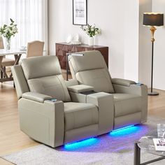 two reclining chairs with blue lights on the armrests in a living room