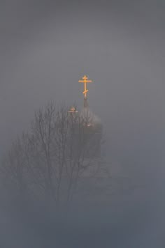 a cross on top of a church in the fog