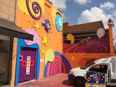 a white van parked in front of a colorful building