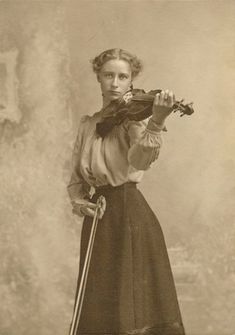 an old photo of a woman holding a violin