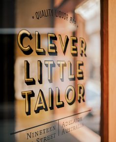 there is a glass sign that says clever little tailor