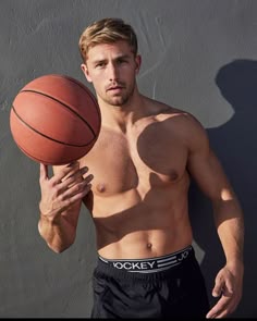 a shirtless man holding a basketball in his right hand