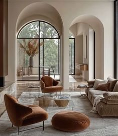 a living room filled with lots of furniture next to tall arched windows on either side of the wall