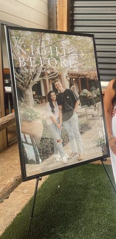 a man and woman standing in front of a sign with the cover of their book