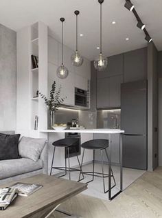 a living room filled with furniture next to a kitchen