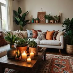 a living room filled with lots of plants and candles on top of a coffee table