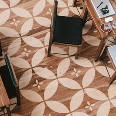 an overhead view of a table and chairs in a room with wood flooring that has circles on it