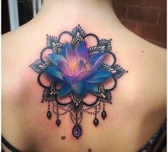 the back of a woman's neck with a blue flower on it