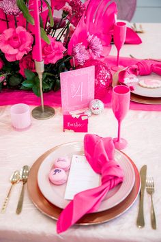 the table is set with pink napkins and place settings for an elegant dinner party