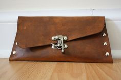 a brown leather purse sitting on top of a wooden floor next to a white wall