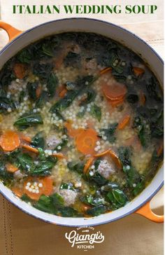 a pot filled with soup and vegetables on top of a white cloth next to an orange handled utensil