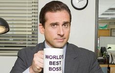 a man holding a coffee cup with the words world's best boss on it