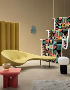 a living room filled with furniture next to a colorful wall hanging on the side of it