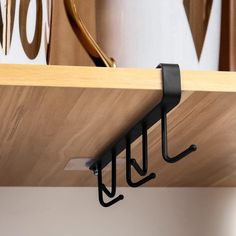 a close up of a shelf with two hooks on it