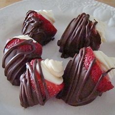 four chocolate covered strawberries on a white plate