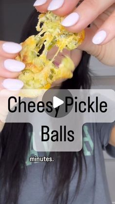 a woman with long nails holding up a piece of cheesey pickle balls to her face