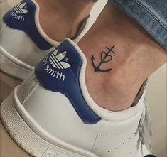 a person with a small anchor tattoo on their foot