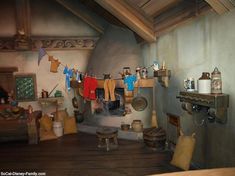 an old fashioned kitchen with pots and pans on the stove top, clothes hanging out to dry