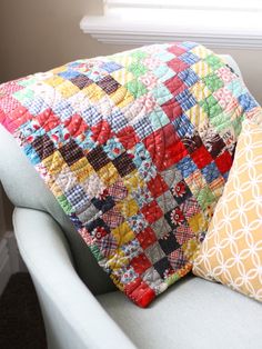 a quilted pillow sitting on top of a blue chair