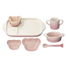 a set of pink dishes and utensils on a white background