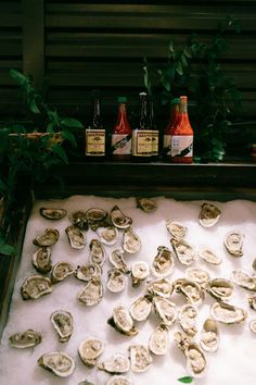 oysters are on display in front of condiments for dipping sauces and ketchup