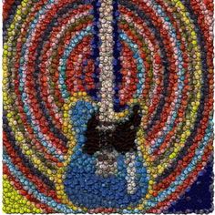 a guitar made out of bottle caps on a white background with an orange, blue, yellow and red circle