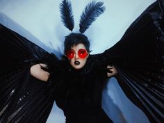 a woman with red eyes and black wings