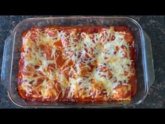 a casserole dish with cheese and sauce in it sitting on a counter top