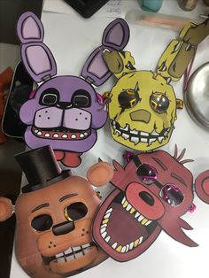 some paper masks are on a table with other items in the shape of rabbits and dogs