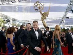 two men in tuxedos are walking down the red carpet at an awards ceremony