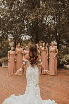 a bride and her bridal party posing for a photo in front of some trees