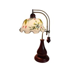 an old fashioned lamp with a flowered shade on it's arm and wooden base