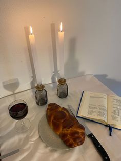 a croissant sitting on top of a glass plate next to an open book