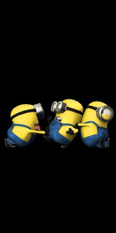 three yellow and blue minion characters in the dark