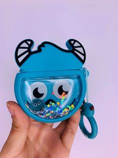 a hand holding a blue case that has eyes and nose decorations on the inside of it