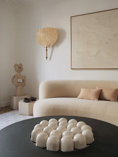 a living room filled with furniture and a painting on the wall over a coffee table